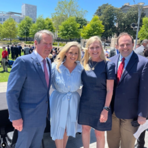 a governor standing with his wife and two education advocates
